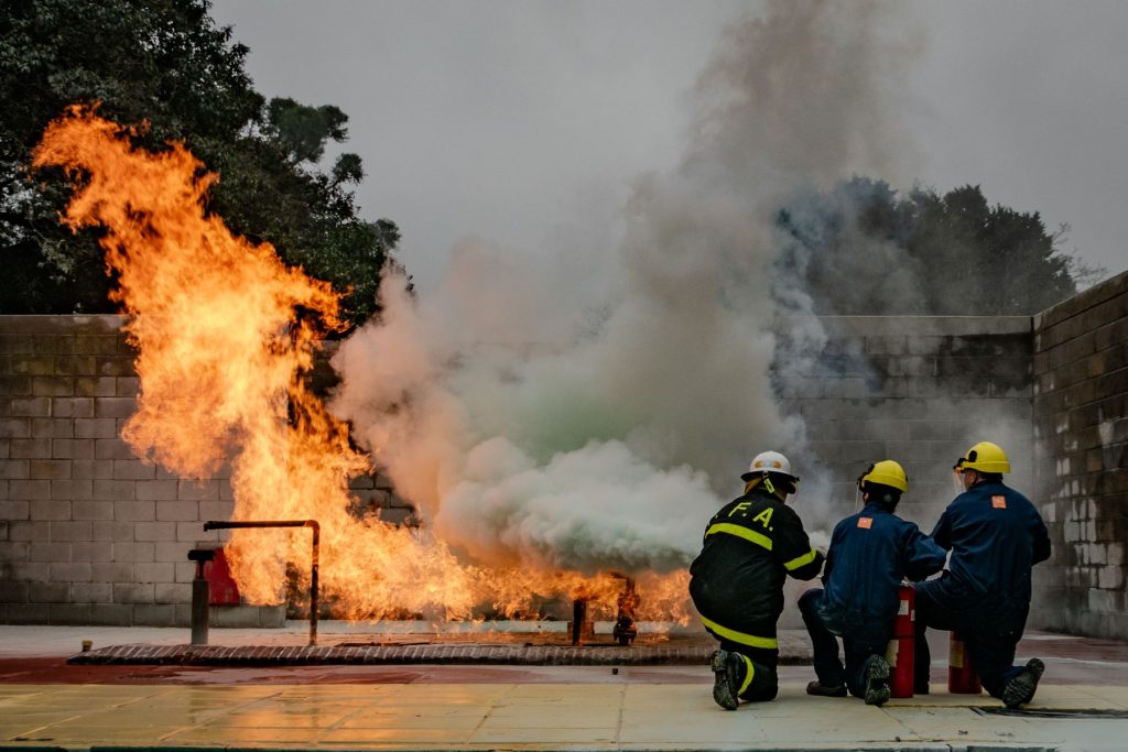 Una squadra in tenuta protettiva affronta un incendio controllato durante un'esercitazione antincendio in campo prova